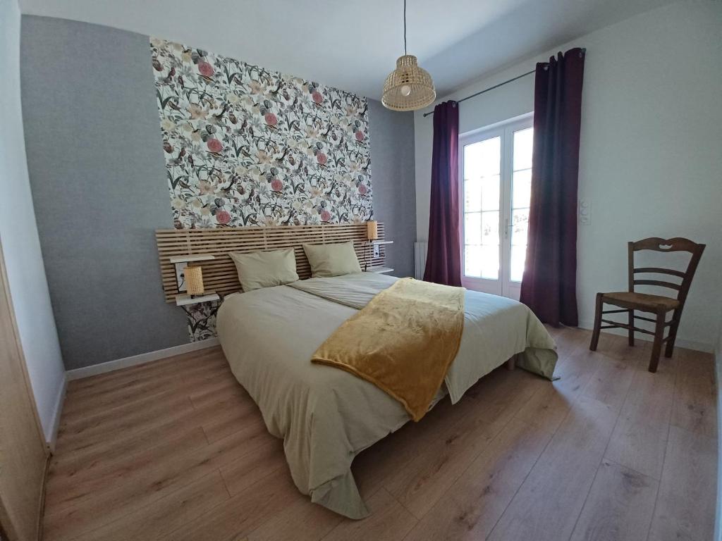 1 dormitorio con 1 cama con pared de flores en Le Fournil de Douasse, en Puycalvel Lautrec