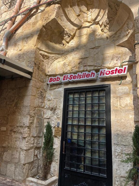 un edificio con una señal sobre una puerta en Bab El-Silsileh Hostel, en Jerusalén