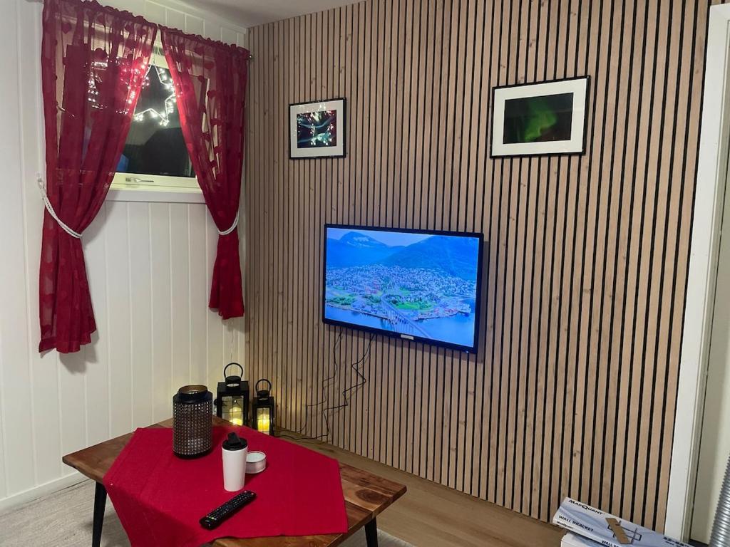 un salon avec une télévision sur un mur dans l'établissement Quiet and peaceful apartment, close to everything, à Tromsø