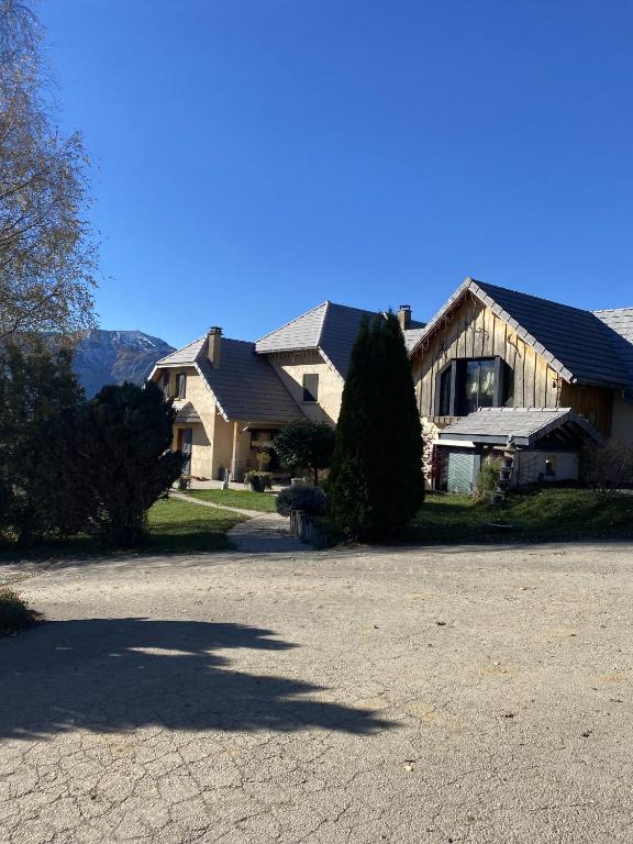 une grande maison avec une allée devant dans l'établissement La Rose des Vents, à Saint-Bonnet-en-Champsaur