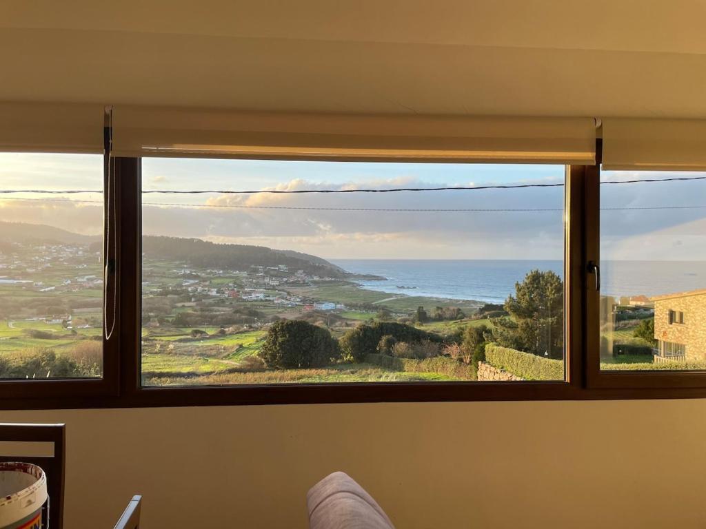 een raam in een kamer met uitzicht op de oceaan bij Casa con vistas impresionantes in A Coruña