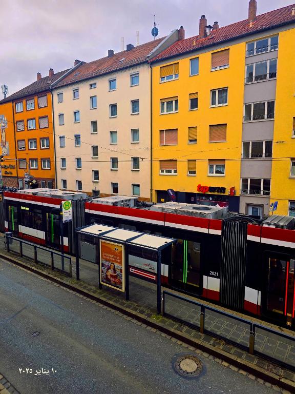 un arrêt de bus sur le côté d'une rue abritant des bâtiments dans l'établissement Komplette 2-Zimmer Wohnung, à Nuremberg