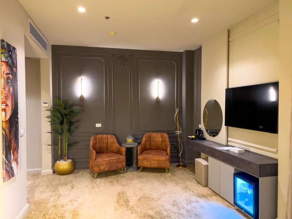 a living room with two chairs and a television at Eastern Al Montazah Hotel in Alexandria