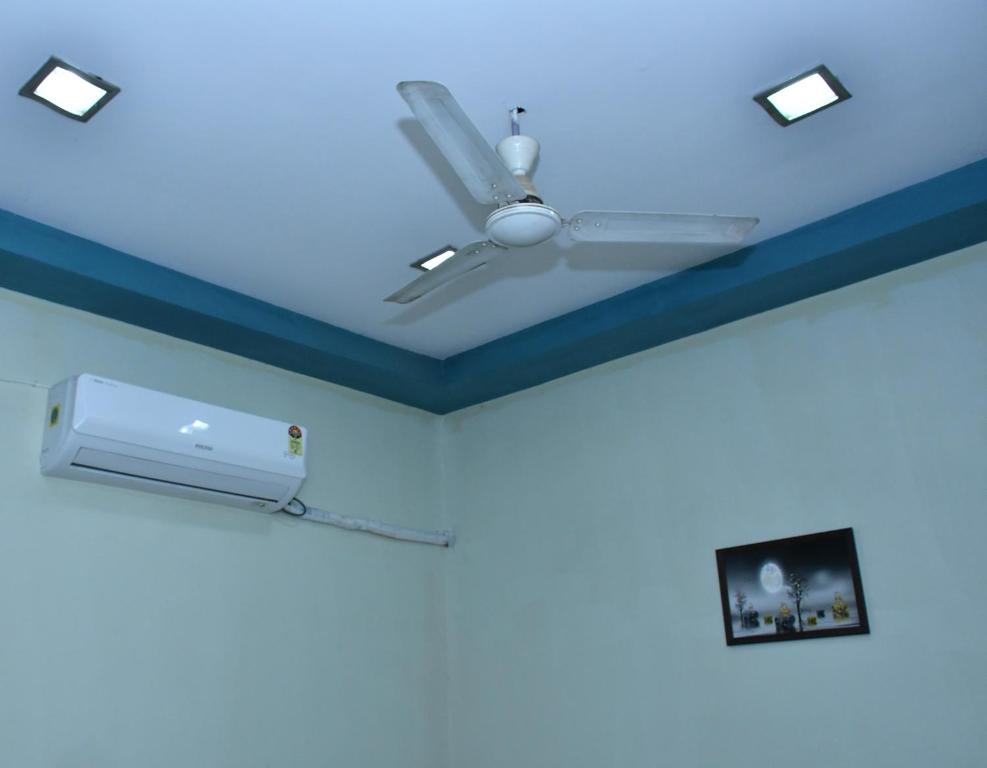 a room with a blue ceiling with a ceiling fan at Happy Home in Jaipur