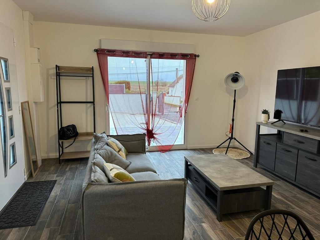 un salon avec un canapé et une télévision dans l'établissement Maison tout confort 2 chambres, à Saint-Pierre-de-Varengeville