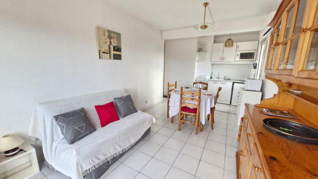 un salon avec un canapé et une cuisine dans l'établissement Bonna Blanca Appartement à 50 m de la plage , secteur marché - Clim, à Saint Cyprien Plage