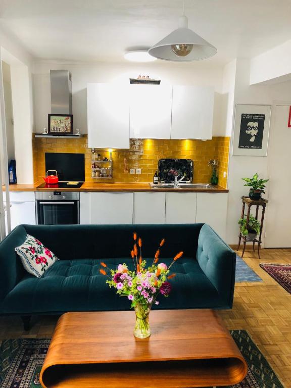 un salon avec un canapé vert et une table dans l'établissement Beautiful and bright appartement in Montmartre, à Paris