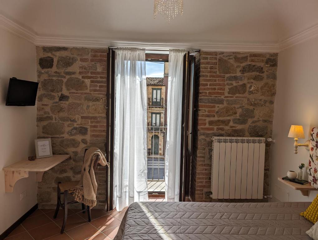 a bedroom with a bed and a large window at Passo del Mattino in Locati