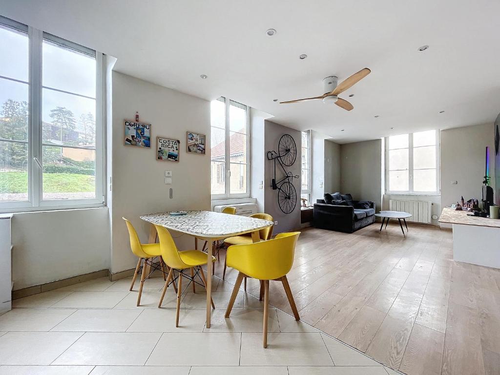 un salon avec une table et des chaises jaunes dans l'établissement La roue libre 3 chambres - 1er étage au centre ville de L'Arbresle, à Éveux