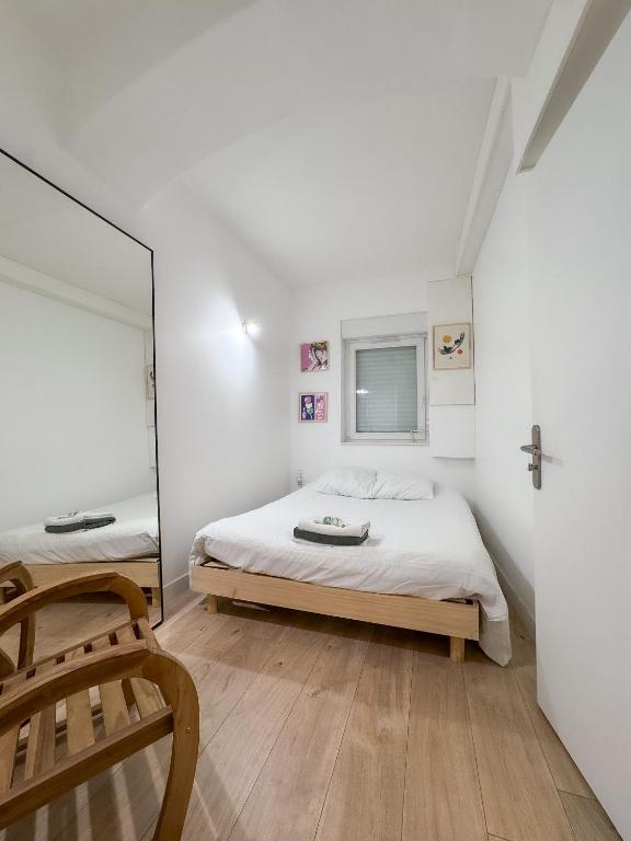 une chambre avec un lit et un miroir dans l'établissement Héra, à Caen