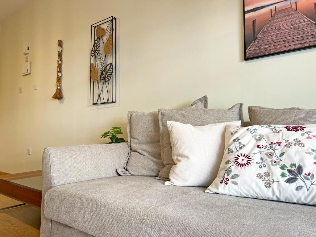 a couch with pillows on it in a living room at Albert's Apartment Mackenzie 001 in Larnaka