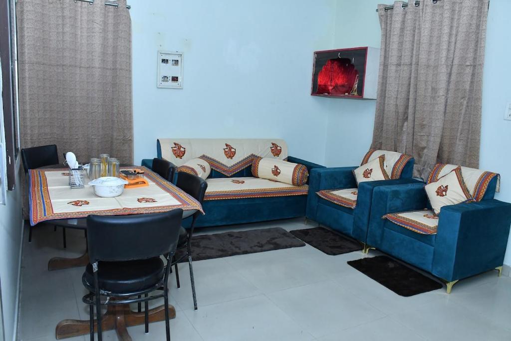 a living room with a blue couch and a table at Independent House in Jaipur in Jaipur