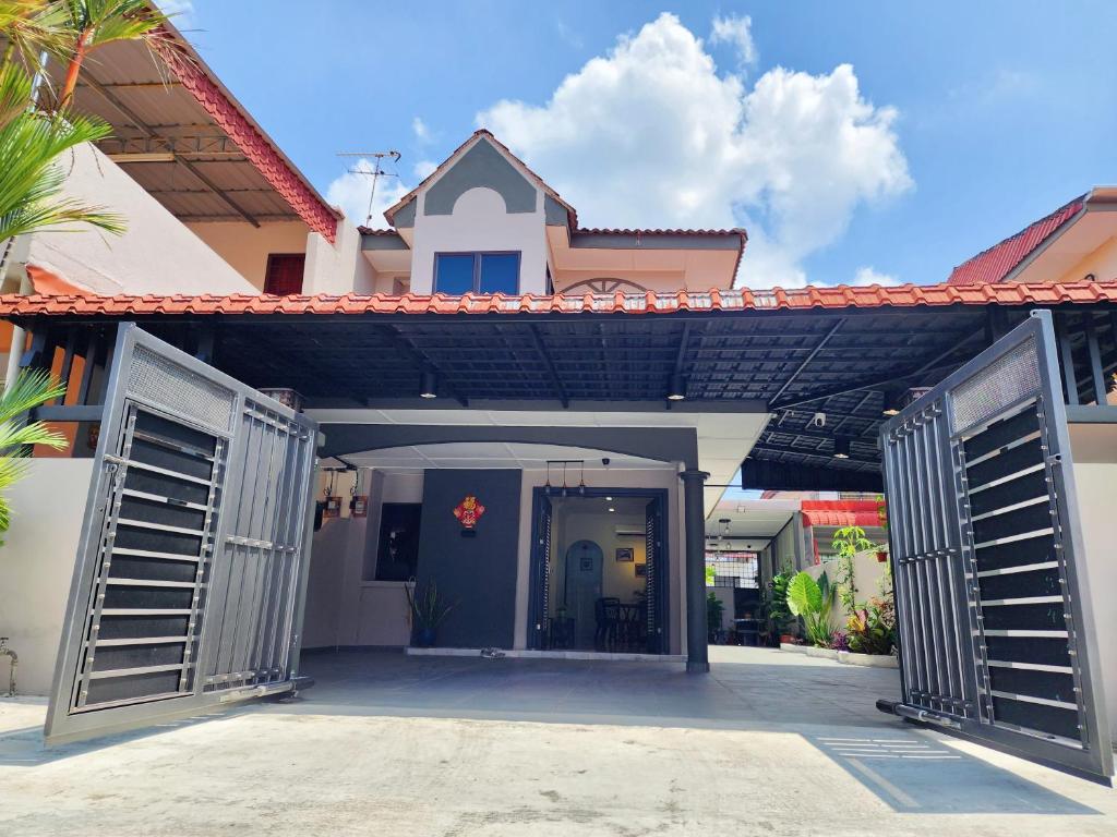 una casa con dos puertas abiertas delante de ella en IPOH Taman Pelangi Double Storey Homestay, en Ipoh