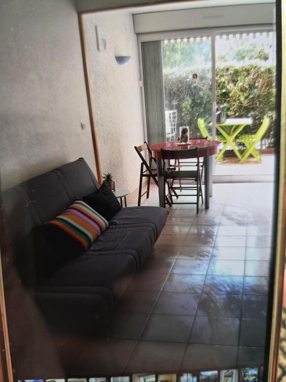 un salon avec un canapé et une table dans l'établissement Appartement Saint-cyprien plage, à Saint Cyprien Plage