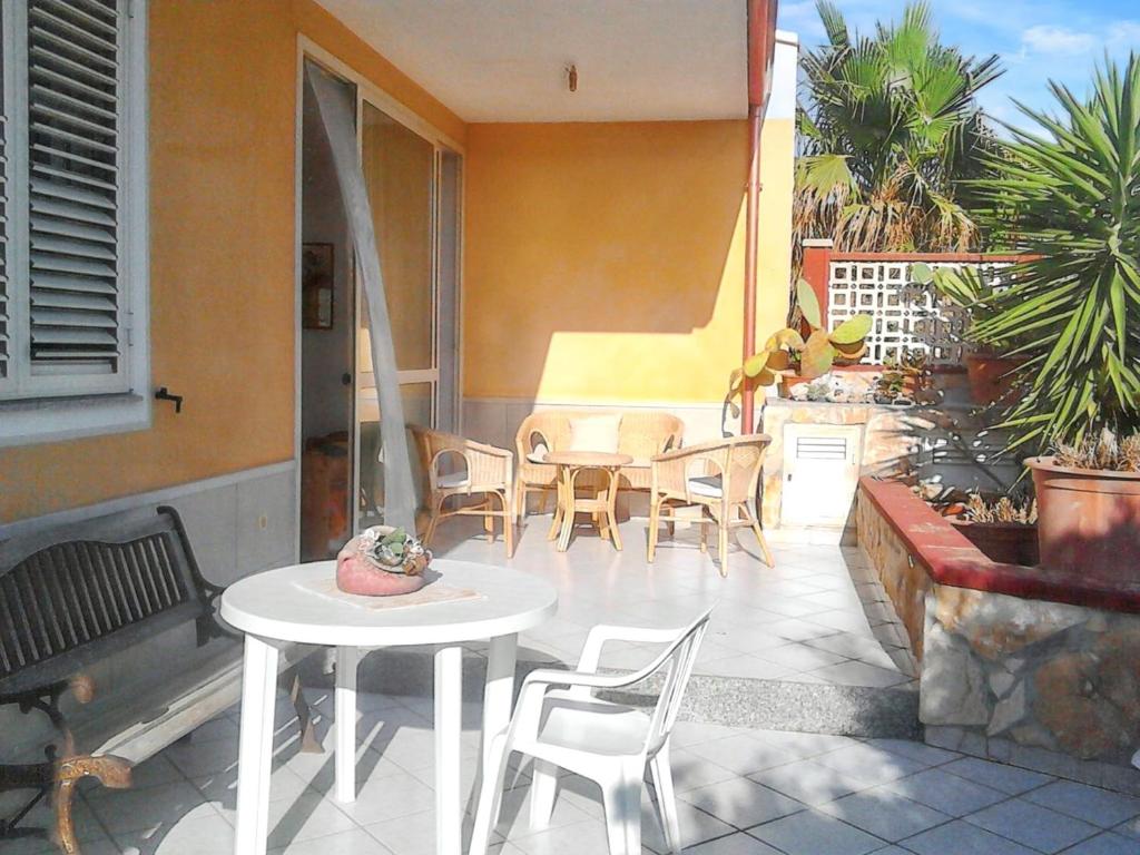 Un patio con una mesa blanca y sillas en un patio. en Charming House in Santa Maria del Focallo with Enclosed Garden, en Santa Maria del Focallo