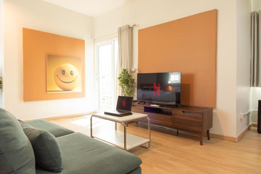 a living room with a couch and a tv at Samyan Story Boutique Hotel in Bangkok