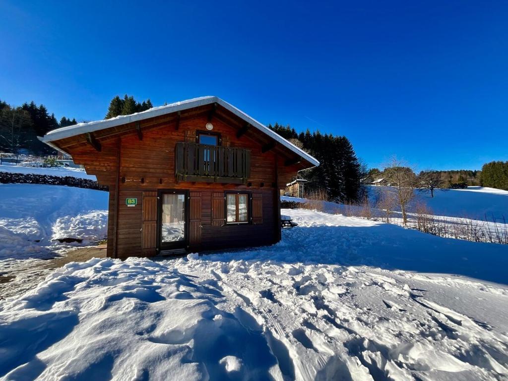 une cabane en rondins avec de la neige au sol dans l'établissement Chalet Les 3 Lueurs, authentique au pied de pistes, à Xonrupt-Longemer