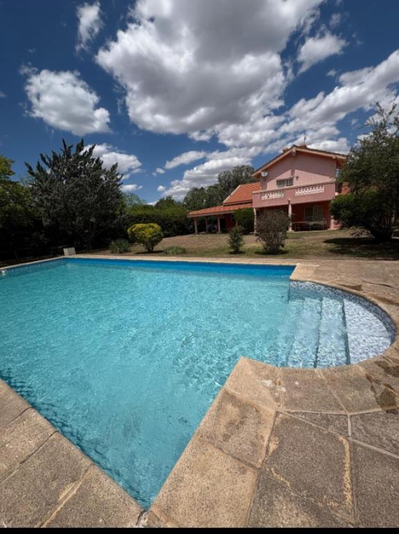 a large blue swimming pool in front of a house at Sauces Las Chacras in Juana Koslay 