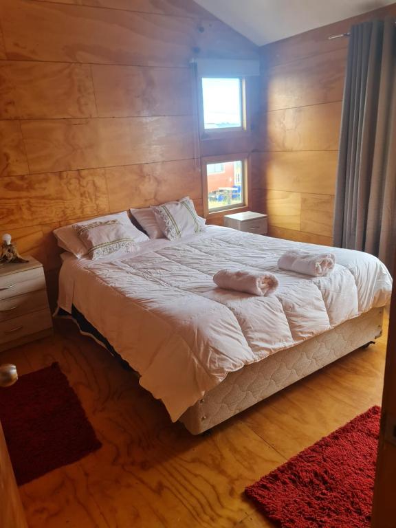 a bedroom with a bed with two towels on it at cabaña vista mágica in Castro