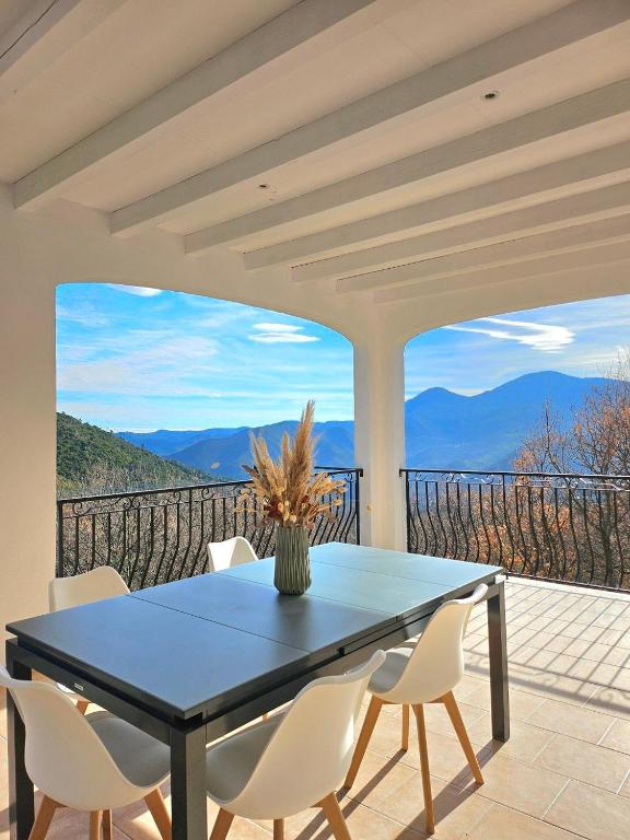 une table et des chaises sur un balcon avec vue dans l'établissement Spacieux haut de villa 3 chambres Venaco, à Venaco