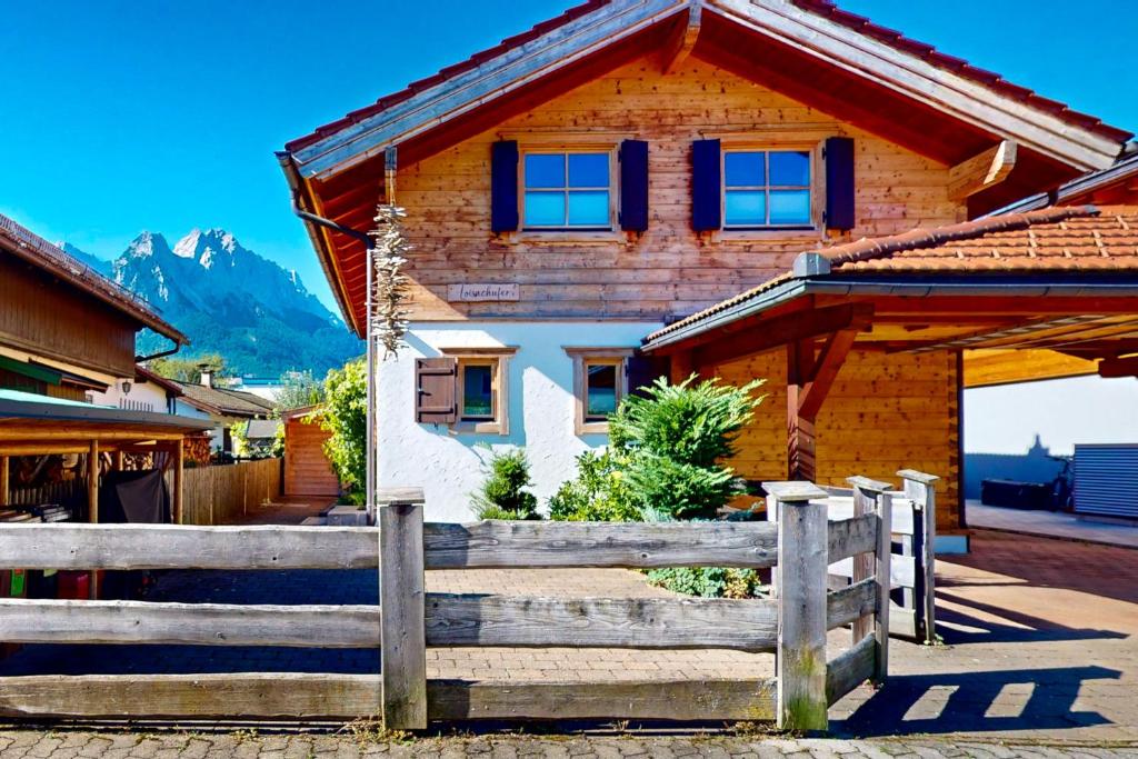 a wooden house with a fence in front of it at Ferienhaus Loisachufer in Garmisch-Partenkirchen
