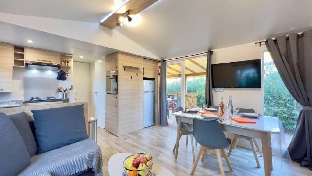 un salon avec un canapé et une table dans l'établissement Mobil-Home Les Lauriers Roses Camping Siblu 4****, à Fréjus