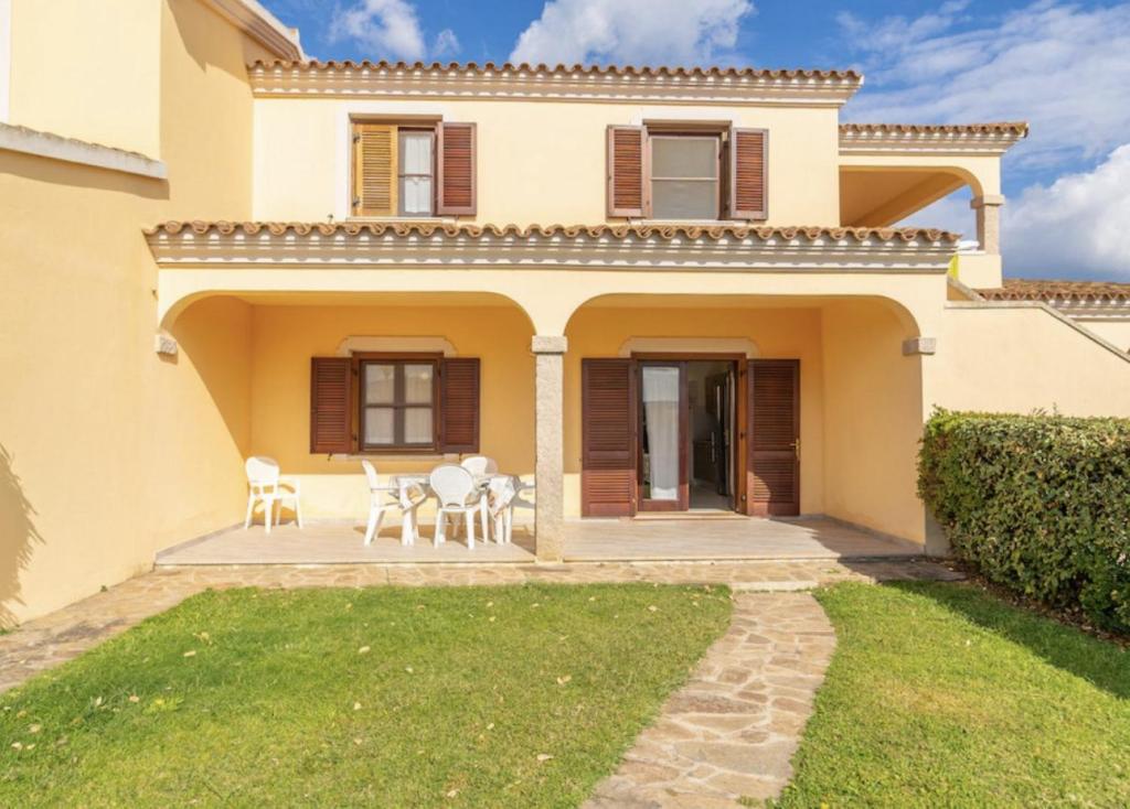 a house with a patio and lawn in front of it at La Cinta Apartments in San Teodoro
