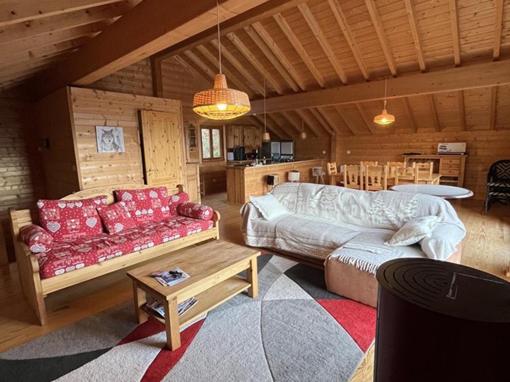 un salon avec un canapé et une table dans l'établissement Chalet spacieux avec balcon et cuisine équipée - FR-1-787-112, à Laveissière