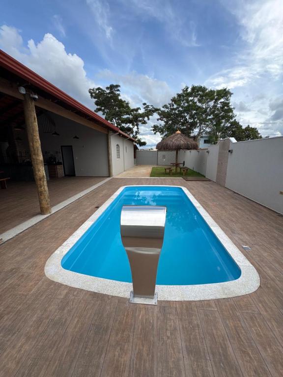 a blue swimming pool on a patio with a table at Espaço Lara Eventos Igarapé in Igarapé