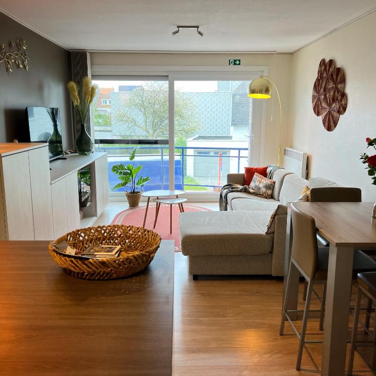 a living room with a couch and a table at Duinhelm Vakantiestudio Mariakerke - A cosy place by the sea in Ostend