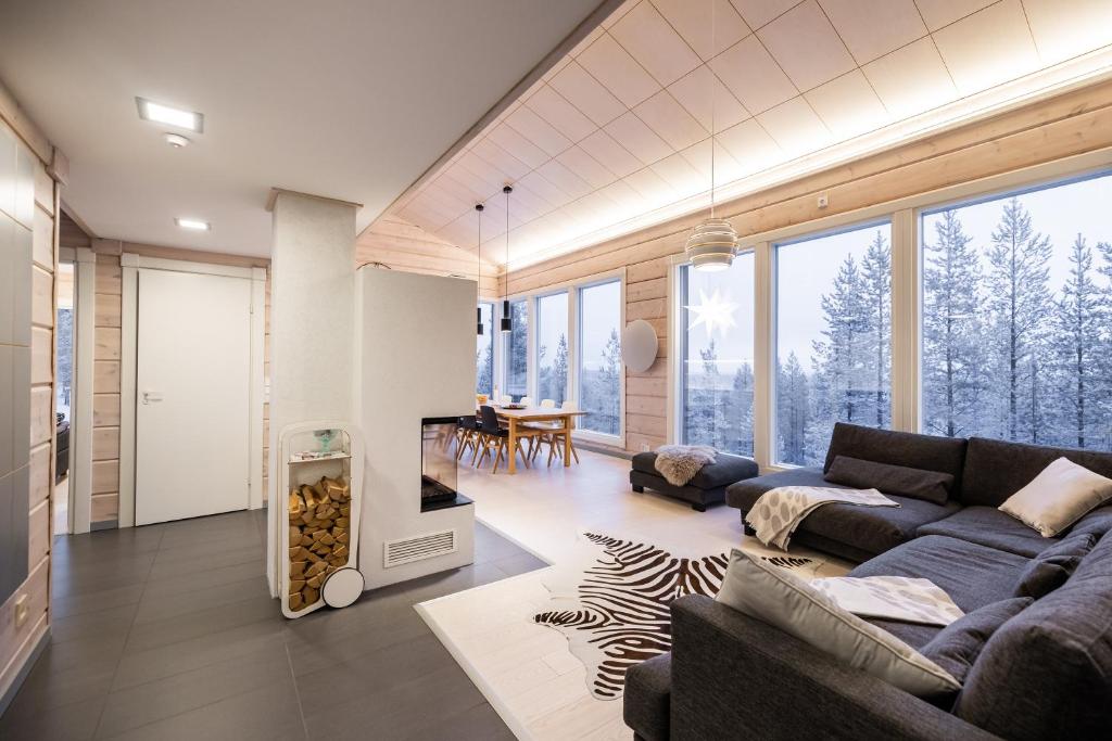 a living room with a couch and a fireplace at Villa Välke - Relax In Style in Pyhätunturi