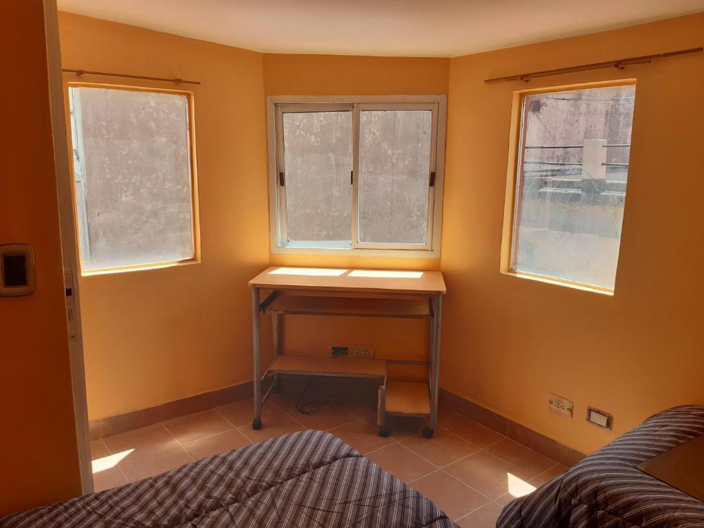 a bedroom with a desk and two windows at Casa Escalera Caracol in Buenos Aires