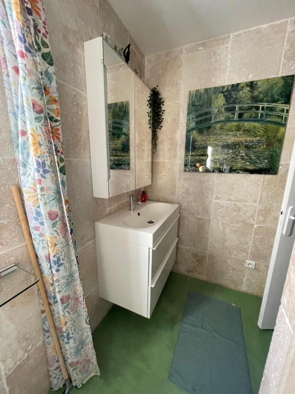 een badkamer met een witte wastafel en een spiegel bij Agapi Mou in Les Baux-de-Provence