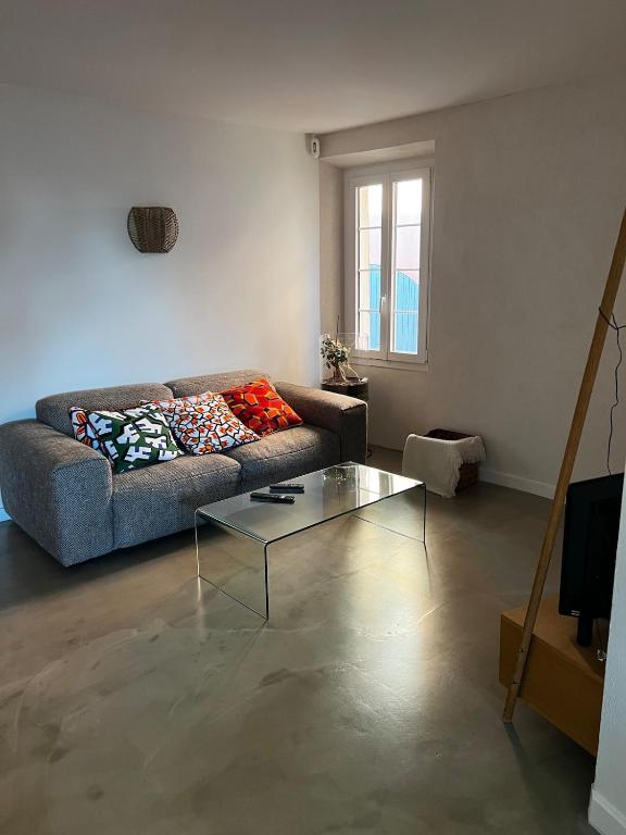 un salon avec un canapé et une table en verre dans l'établissement Jolie maison de village, à Bormes-les-Mimosas
