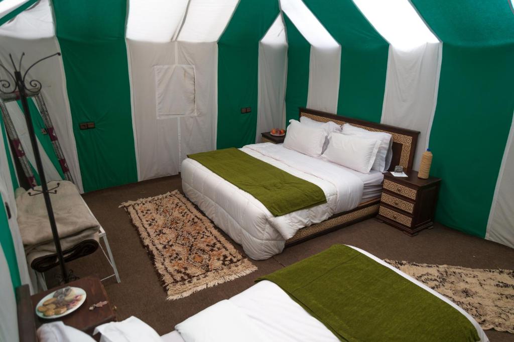 Ένα ή περισσότερα κρεβάτια σε δωμάτιο στο Desert Camp Merzouga Nights