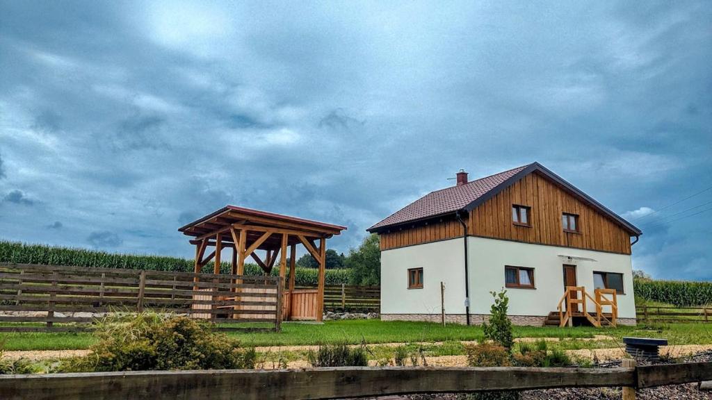 a barn and a house with a wooden roof at Wellness chata se saunou a vířivkou 2 in Žirovnice