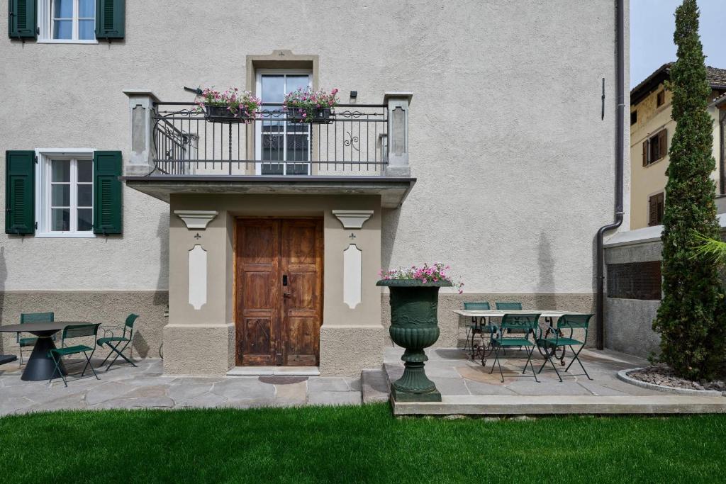 a building with a wooden door and a balcony with flowers at Villa Donata - Luxuriöses & großzügiges Apartment im Herzen von Kaltern, mit Innenhof, kostenlosem Parkplatz direkt am Haus in Caldaro