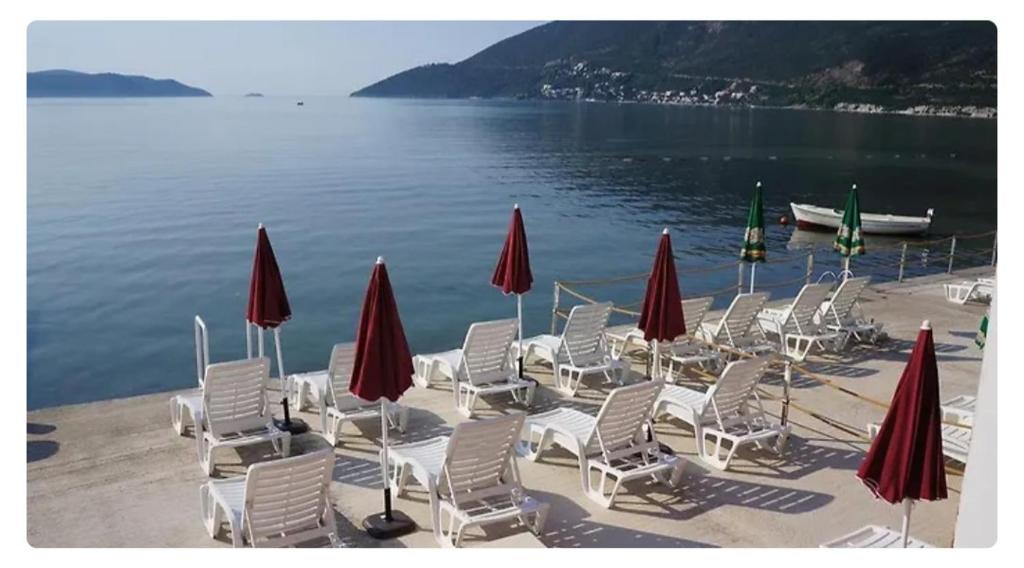 grupa krzeseł i parasoli na plaży w obiekcie Дарина w mieście Igalo