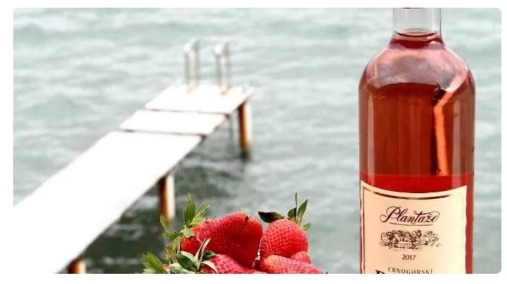 a bottle of strawberry sauce next to some strawberries at Дарина in Igalo