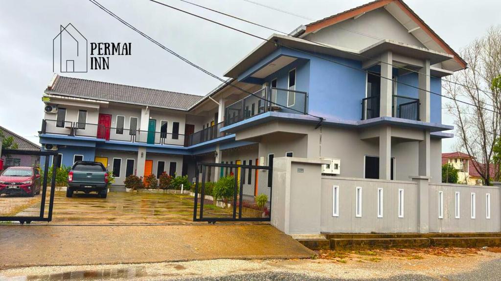 a blue house with a fence in front of it at Roomstay Homestay Permai Inn Pekan in Pekan