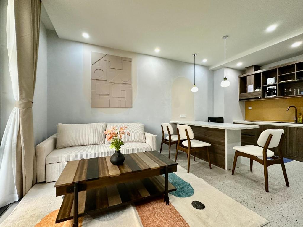 a living room and kitchen with a couch and a table at Meridian apartment service at Marina Long beach Phu Quoc in Phú Quốc