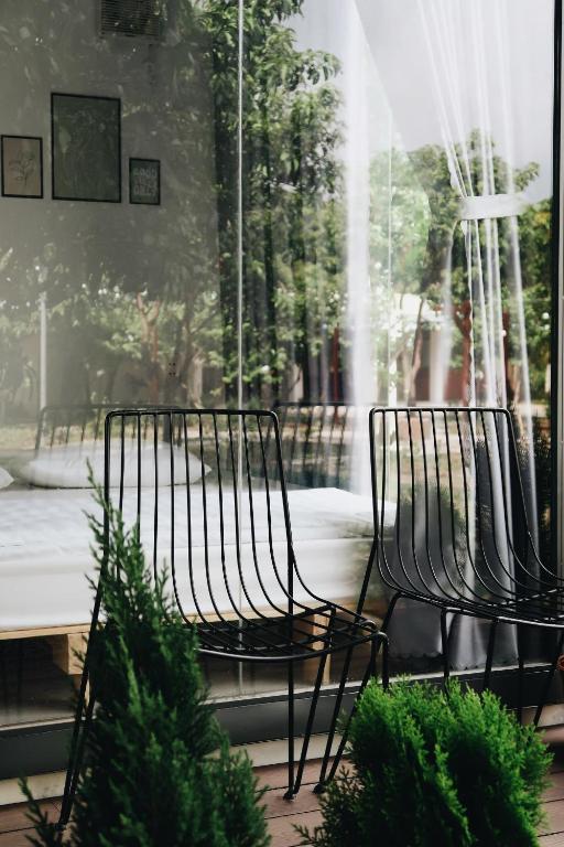 two chairs in front of a window with a fountain at Homestay t h o n g d o n g in Ấp Phước Hòa