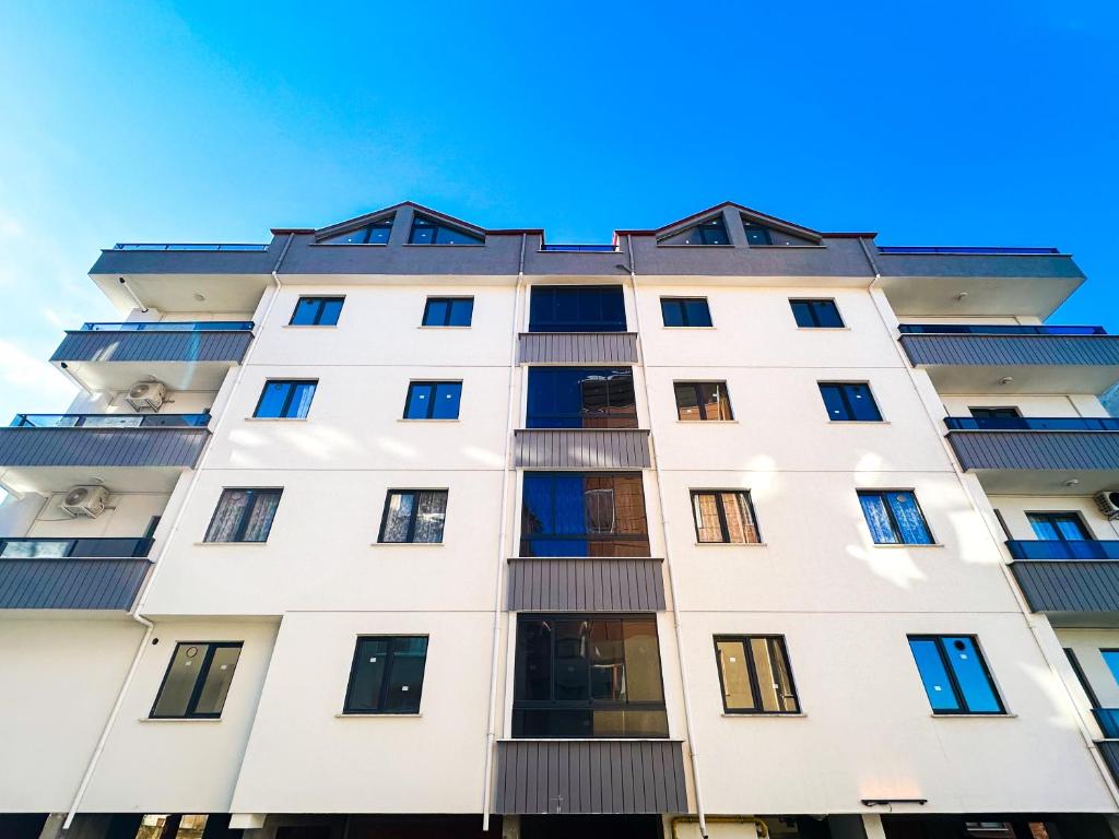 a tall white building with windows at Mukka Apart Hotel - شقق موكا الفندقية in Trabzon