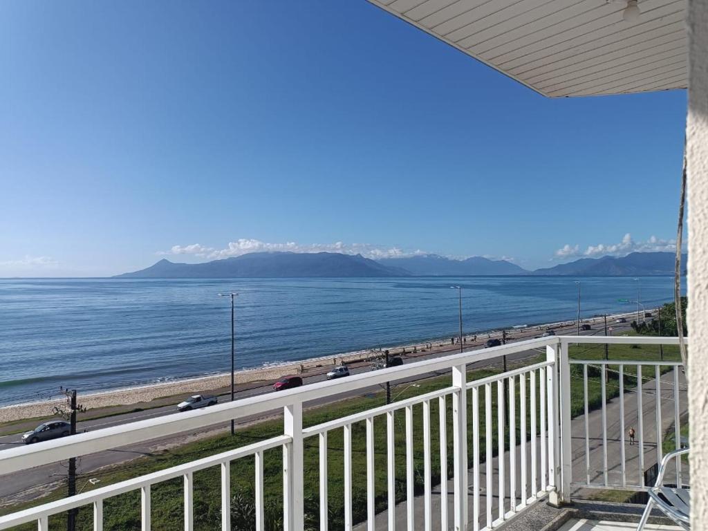 einen Balkon mit Blick auf den Strand und das Meer in der Unterkunft Praia de Massaguaçu in Caraguatatuba