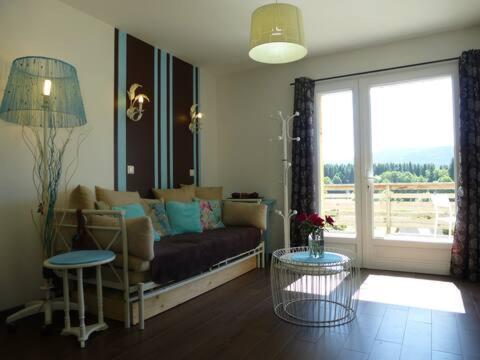 a living room with a couch and a large window at AB Bel appartement 1 à 4 pers face vallée 3 étoiles WIFI in Le Tholy