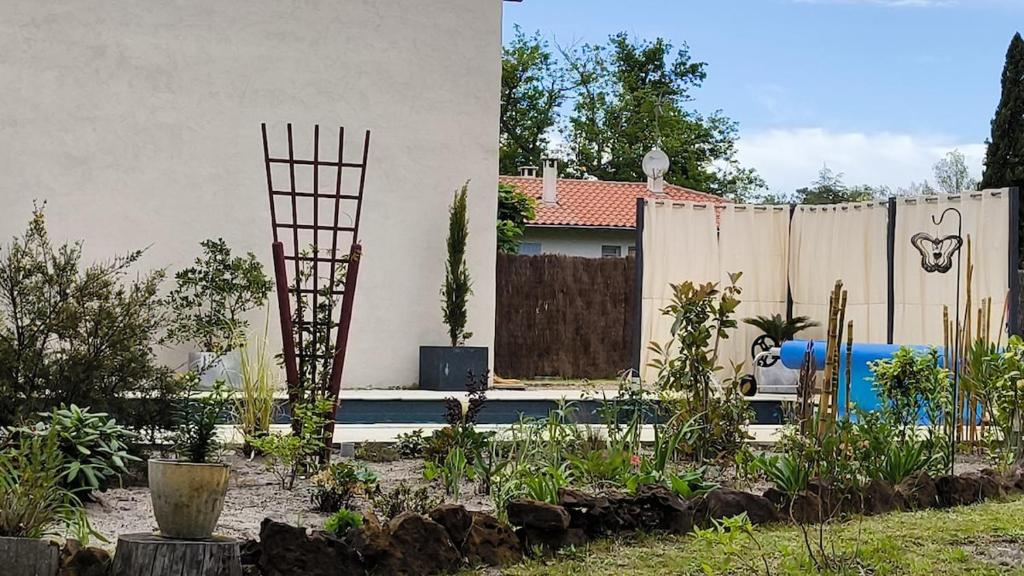 un jardin avec une clôture et une bouche de feu bleu dans l'établissement Logement cosy, piscine, terrain de pétanque, vélos, entre centre ville et lac, à Parentis-en-Born