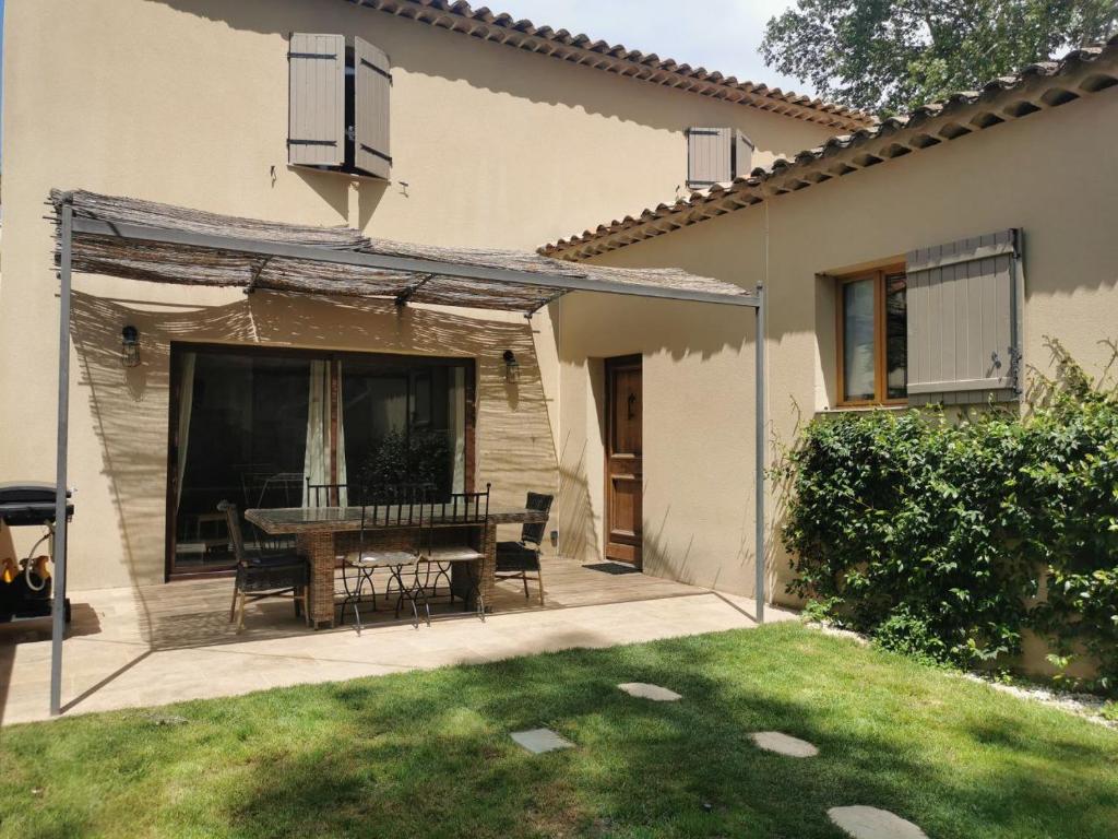 un patio avec une table et des chaises dans une cour dans l'établissement Maison de la bonne fontaine., à Lauris