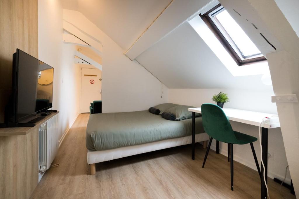une chambre avec un lit, un bureau et une télévision dans l'établissement Le Nid - Studio in Hypercentre - Cathédrale, à Amiens