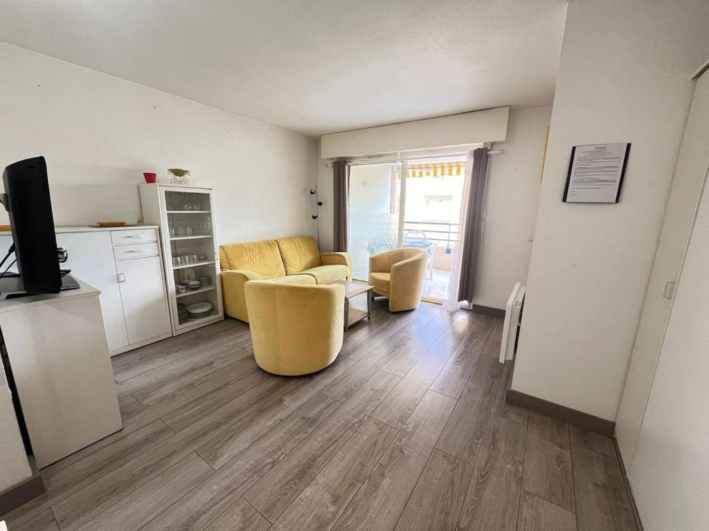 un salon avec un canapé, des chaises et une télévision dans l'établissement Appartement fréjus avec piscine - plage - parking, à Fréjus