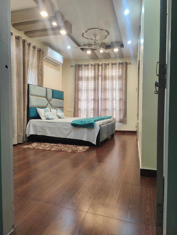 Hotel Akhand Bhawan Homestay 2BHK Apartment, a bedroom with a bed and a large window at Akhand Bhawan Homestay 2BHK Apartment in Varanasi